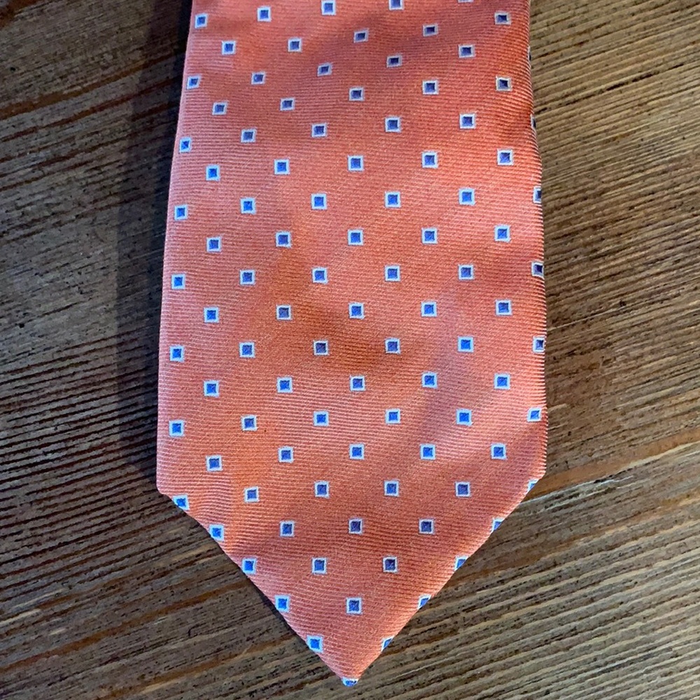 Men’s 7 fold classic Isaia tie. Orange with blue square pattern.